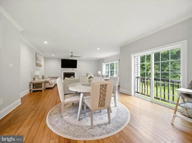 a dining room with wooden floor a glass table and chairs
