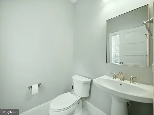 a bathroom with a toilet sink and mirror