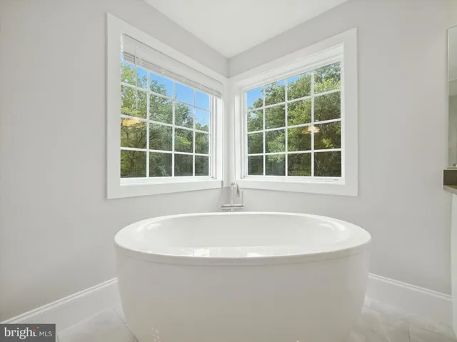a white bath tub sitting in a bathroom next to a window