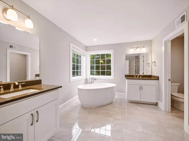 a bathroom with a tub sink and mirror
