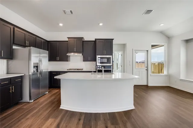 a kitchen with stainless steel appliances a refrigerator and a stove top oven
