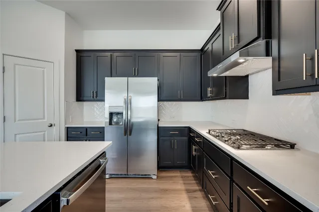a kitchen with stainless steel appliances a refrigerator a stove and a sink