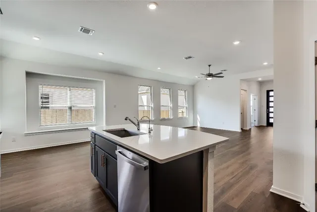 a kitchen that has a sink a stove and wooden floor