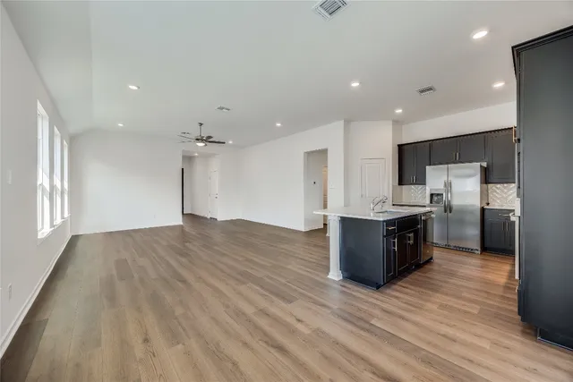 a large kitchen with stainless steel appliances kitchen island granite countertop a large counter top and wooden floors