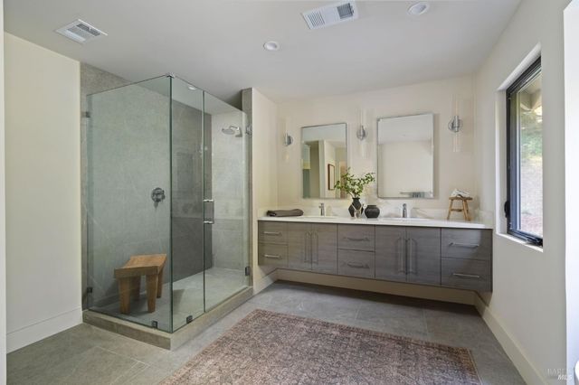 a bathroom with a shower sink and mirror