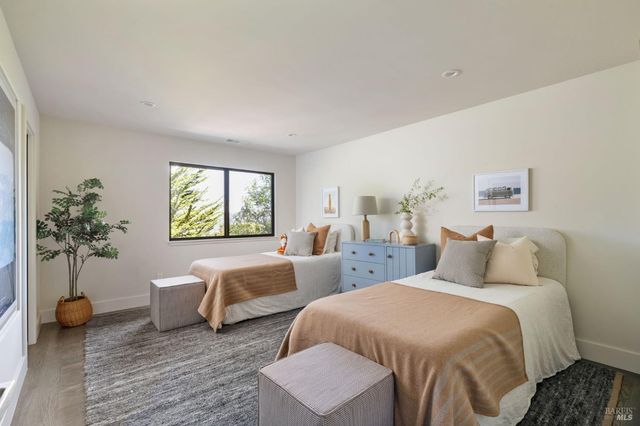 a bedroom with two beds and a potted plant