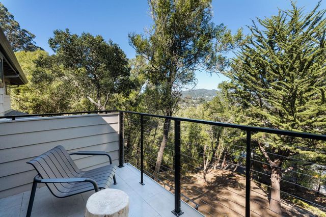 a view of a balcony with chairs and wooden fence