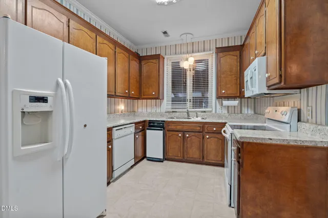 a kitchen with stainless steel appliances granite countertop a refrigerator a sink dishwasher a stove with wooden cabinets and floor