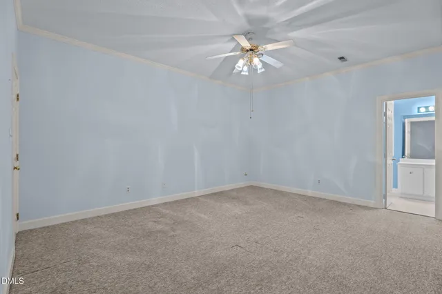a view of an empty room with a chandelier fan