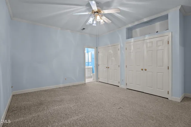 a view of an empty room and chandelier fan
