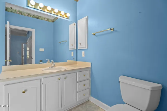 a bathroom with a toilet a sink and mirror