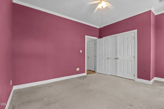 an empty room with a window and a chandelier