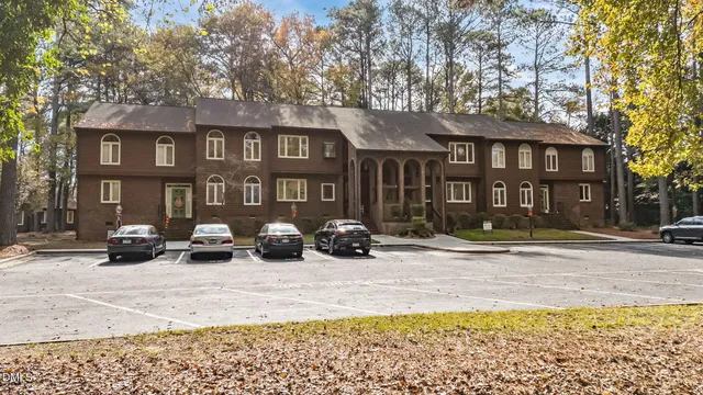 an aerial view of residential houses with outdoor space and trees
