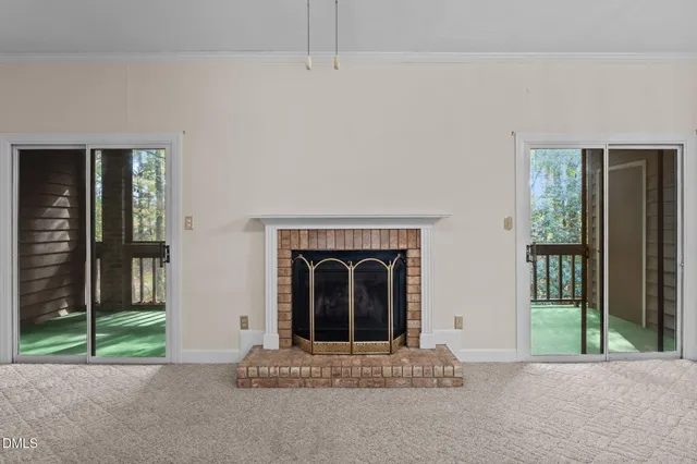 a living room with a fireplace and a floor to ceiling window
