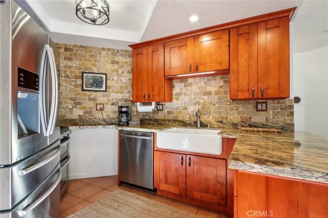a kitchen with stainless steel appliances granite countertop a sink a stove and a refrigerator
