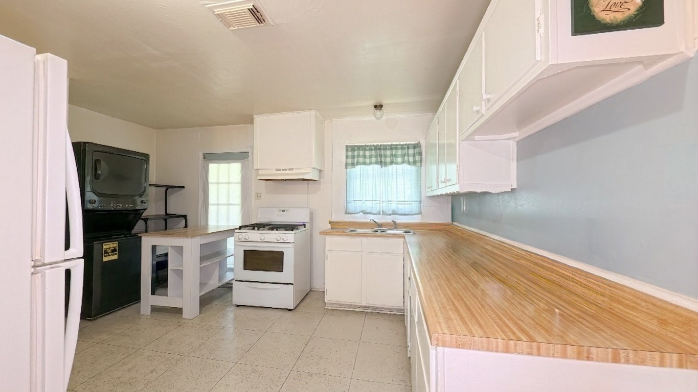5879 Belneath Street Houston, TX 77033 - Photo 6 of 10 a kitchen with a refrigerator stove and microwave