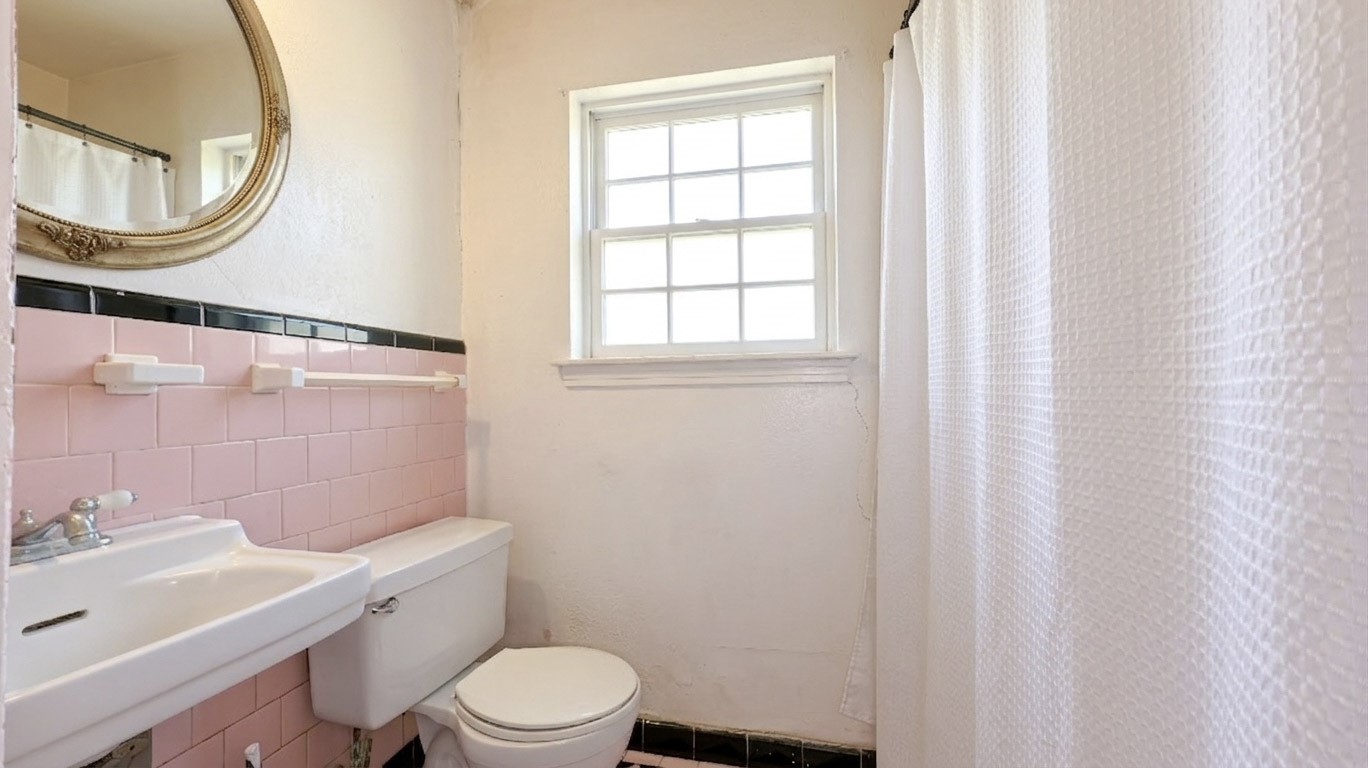5879 Belneath Street Houston, TX 77033 - Photo 8 of 10 a white toilet sitting next to a bathroom sink
