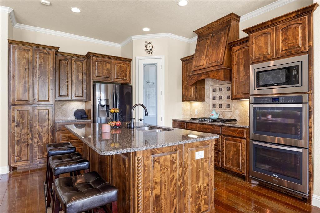 104 Rattling Antler Court Azle, TX 76020 - Photo 6 of 38 Well equipped kitchen with a gas range, double ovens, and plenty of cabinet storage.