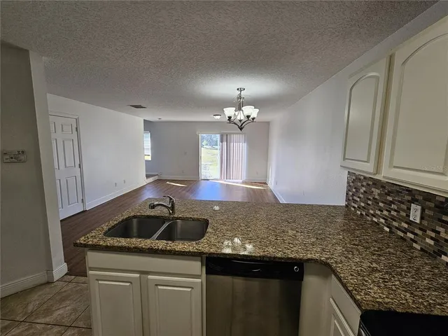 a kitchen with granite countertop a sink and cabinets