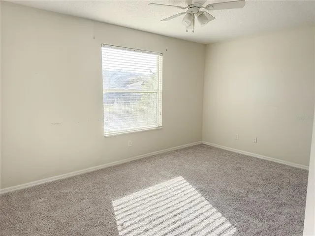 an empty room with fan and a ceiling fan