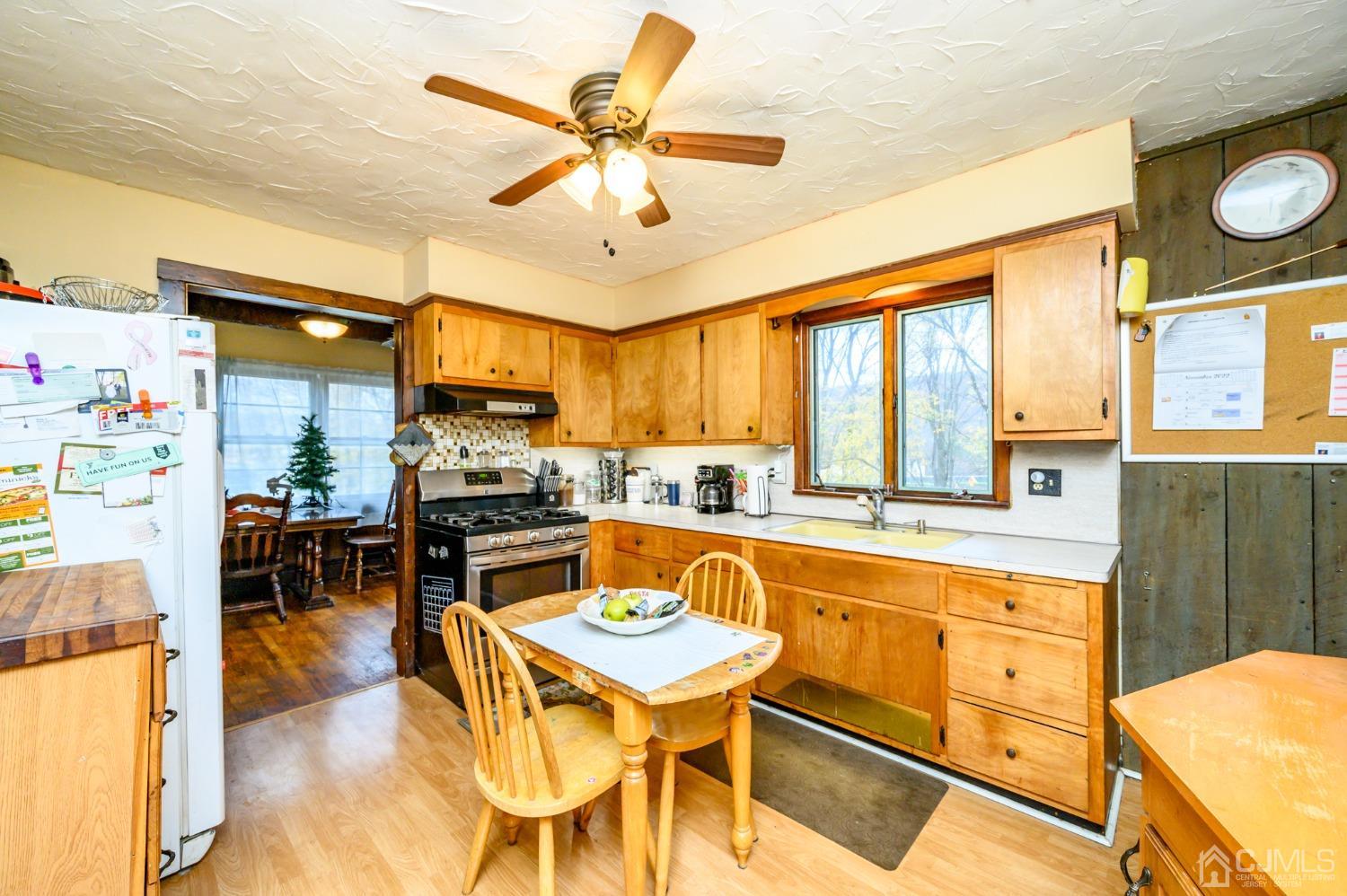 7 Lozaw Road Franklin, NJ 07416 - Photo 12 of 27 a kitchen with stainless steel appliances granite countertop a stove top oven a sink a dining table and chairs with wooden floor