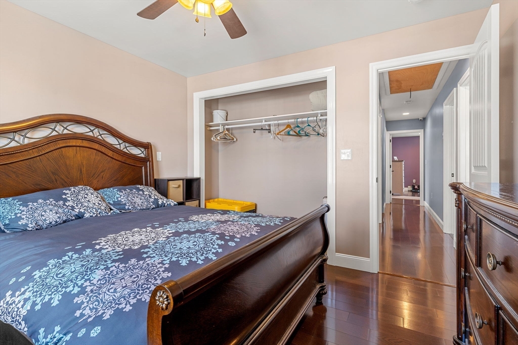 241 Plain Street Lowell, MA 01852 - Photo 13 of 33 a bedroom with a bed and a chandelier