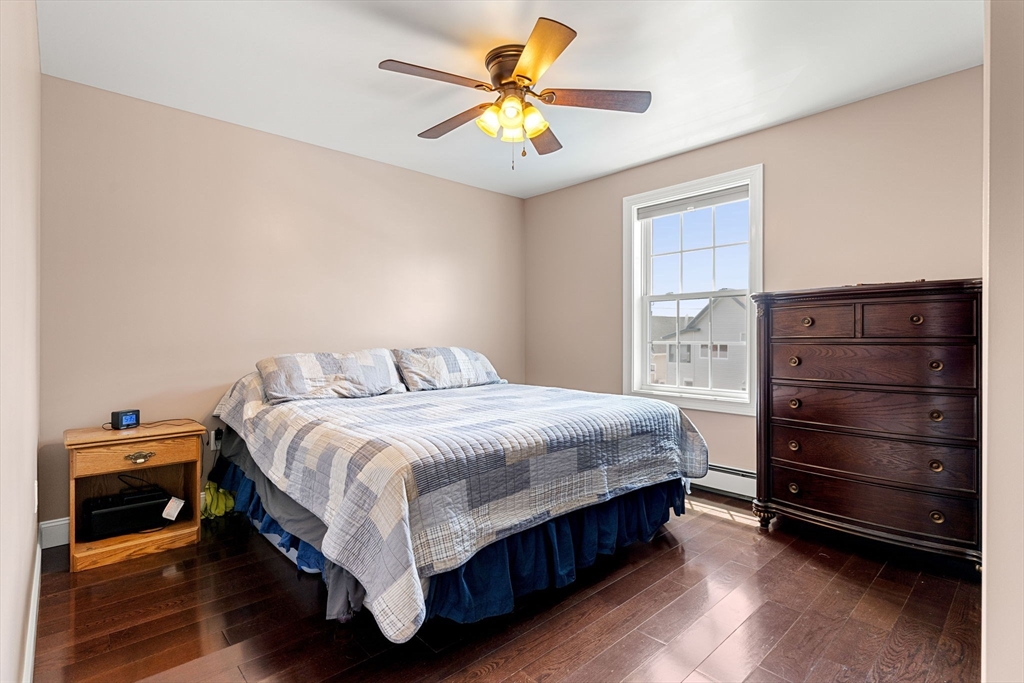 241 Plain Street Lowell, MA 01852 - Photo 17 of 33 a bedroom with a bed and a ceiling fan