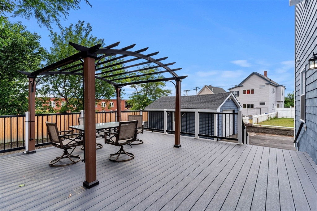 241 Plain Street Lowell, MA 01852 - Photo 32 of 33 a view of roof deck with table and chairs a barbeque with wooden floor and fence