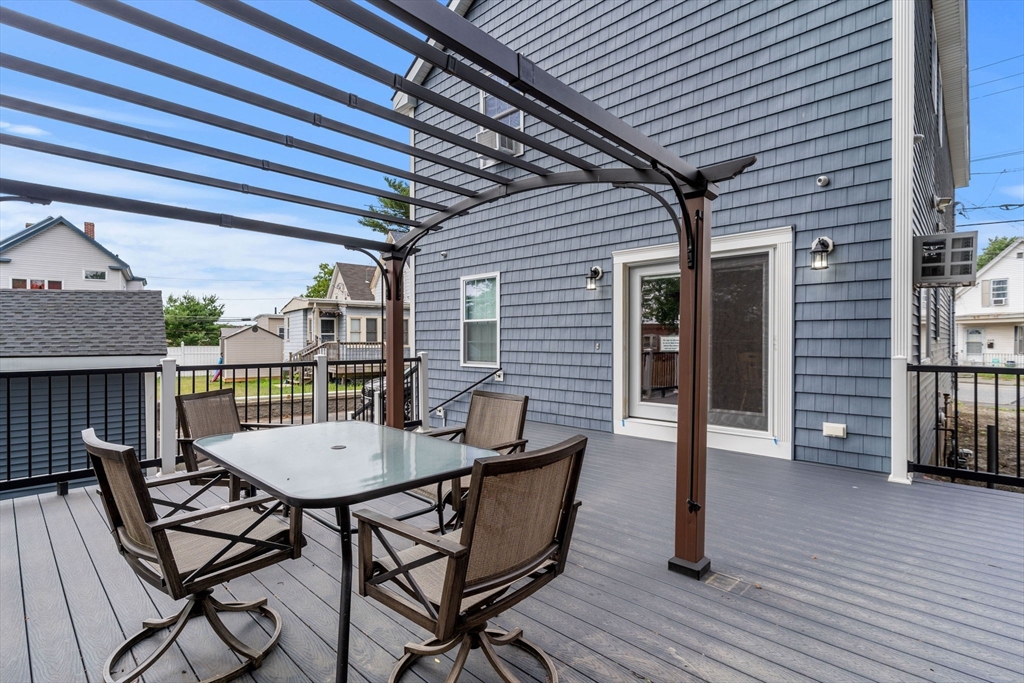 241 Plain Street Lowell, MA 01852 - Photo 33 of 33 a view of a patio with a table and chairs and wooden floor