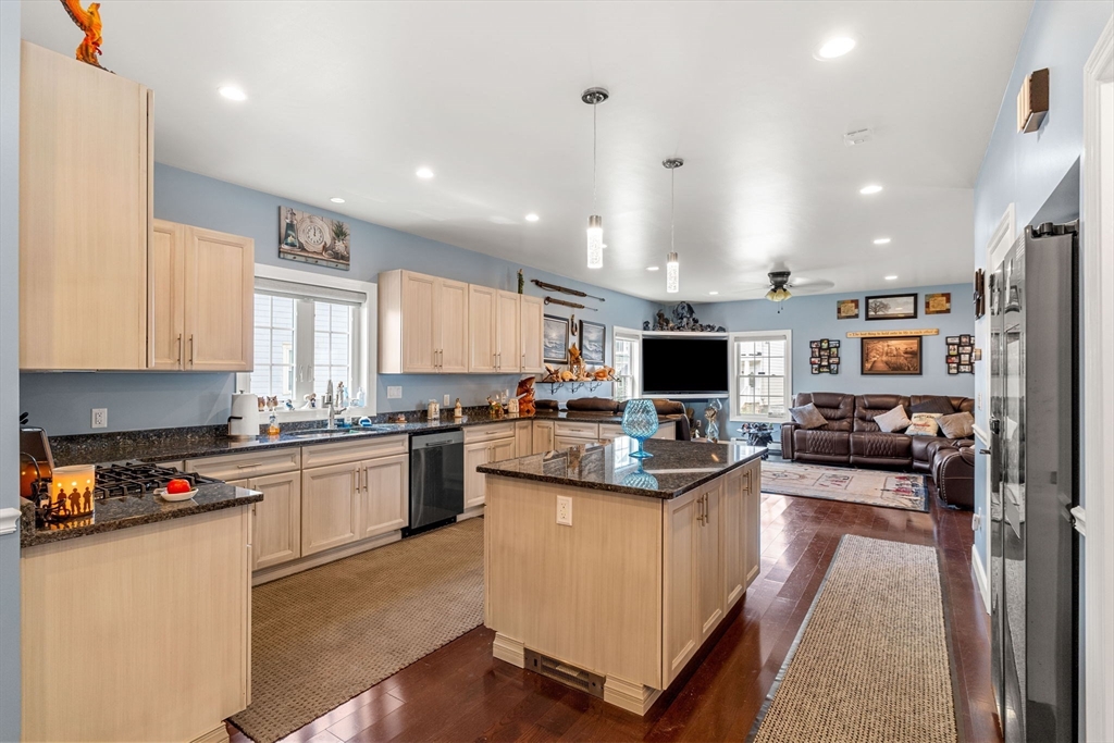 241 Plain Street Lowell, MA 01852 - Photo 6 of 33 a kitchen with kitchen island stainless steel appliances sink cabinets and stove top oven