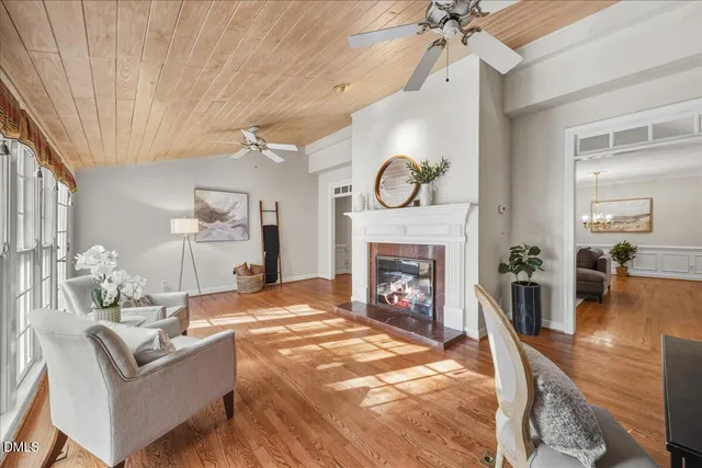 a living room with furniture a clock and a fireplace