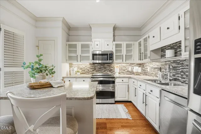 a kitchen with stainless steel appliances granite countertop a stove a sink and a white refrigerator