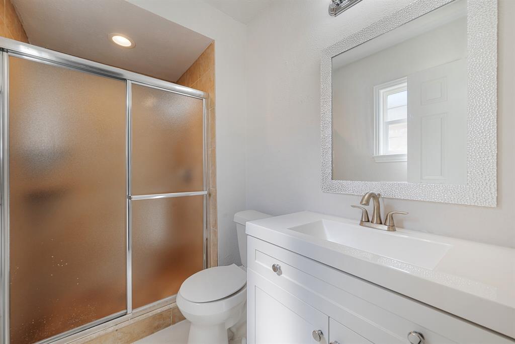 2038 Ash Hill Road Carrollton, TX 75007 - Photo 11 of 28 a bathroom with a shower sink vanity mirror and toilet