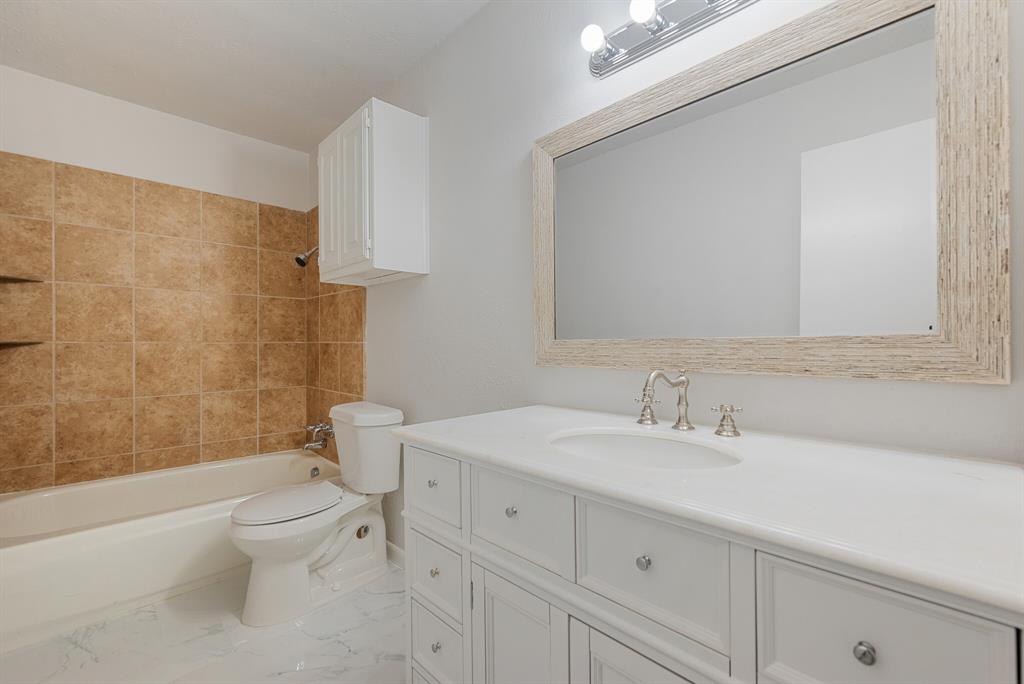 2038 Ash Hill Road Carrollton, TX 75007 - Photo 15 of 28 a bathroom with a sink a toilet and shower