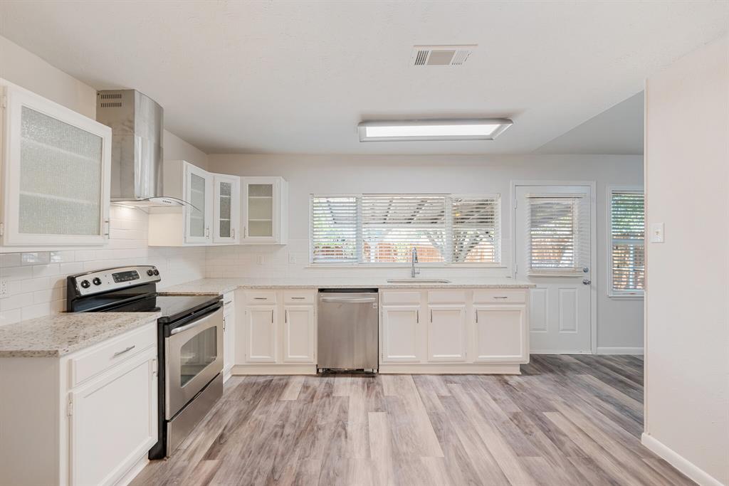 2038 Ash Hill Road Carrollton, TX 75007 - Photo 24 of 28 a kitchen with granite countertop white cabinets and white appliances