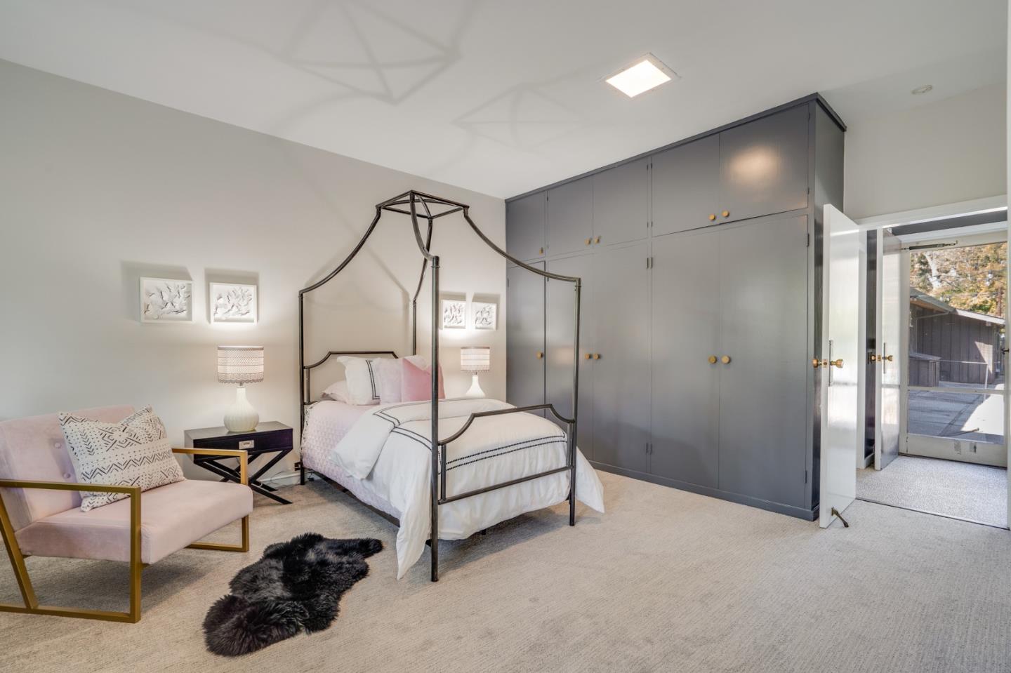 760 Chiltern Road Hillsborough, CA 94010 - Photo 26 of 56 a bedroom with a bed a couch and a chandelier