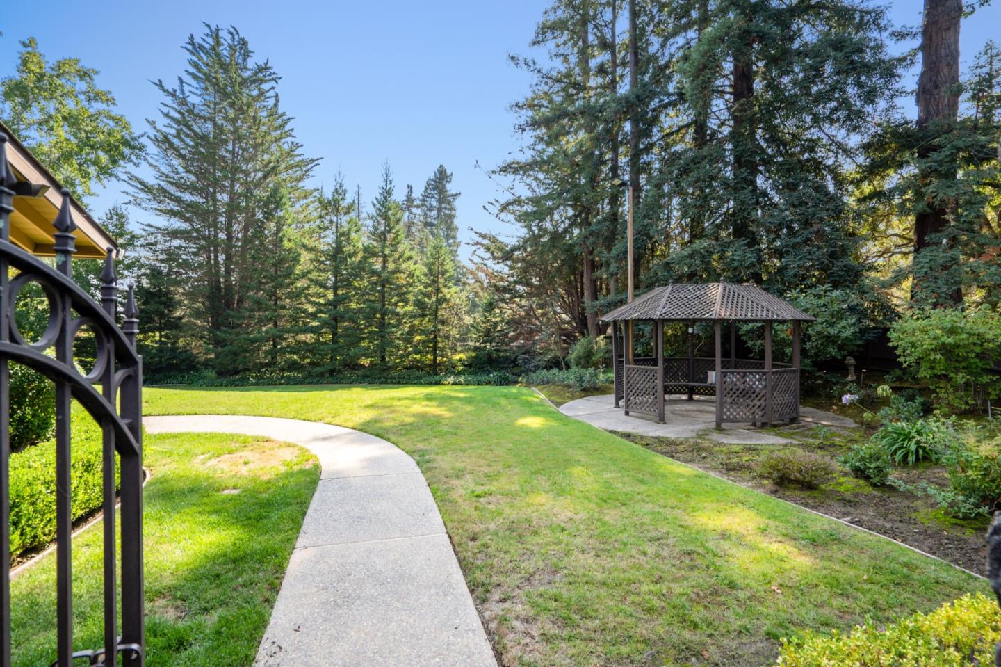 760 Chiltern Road Hillsborough, CA 94010 - Photo 52 of 56 a view of a swimming pool with a table and chairs under an umbrella