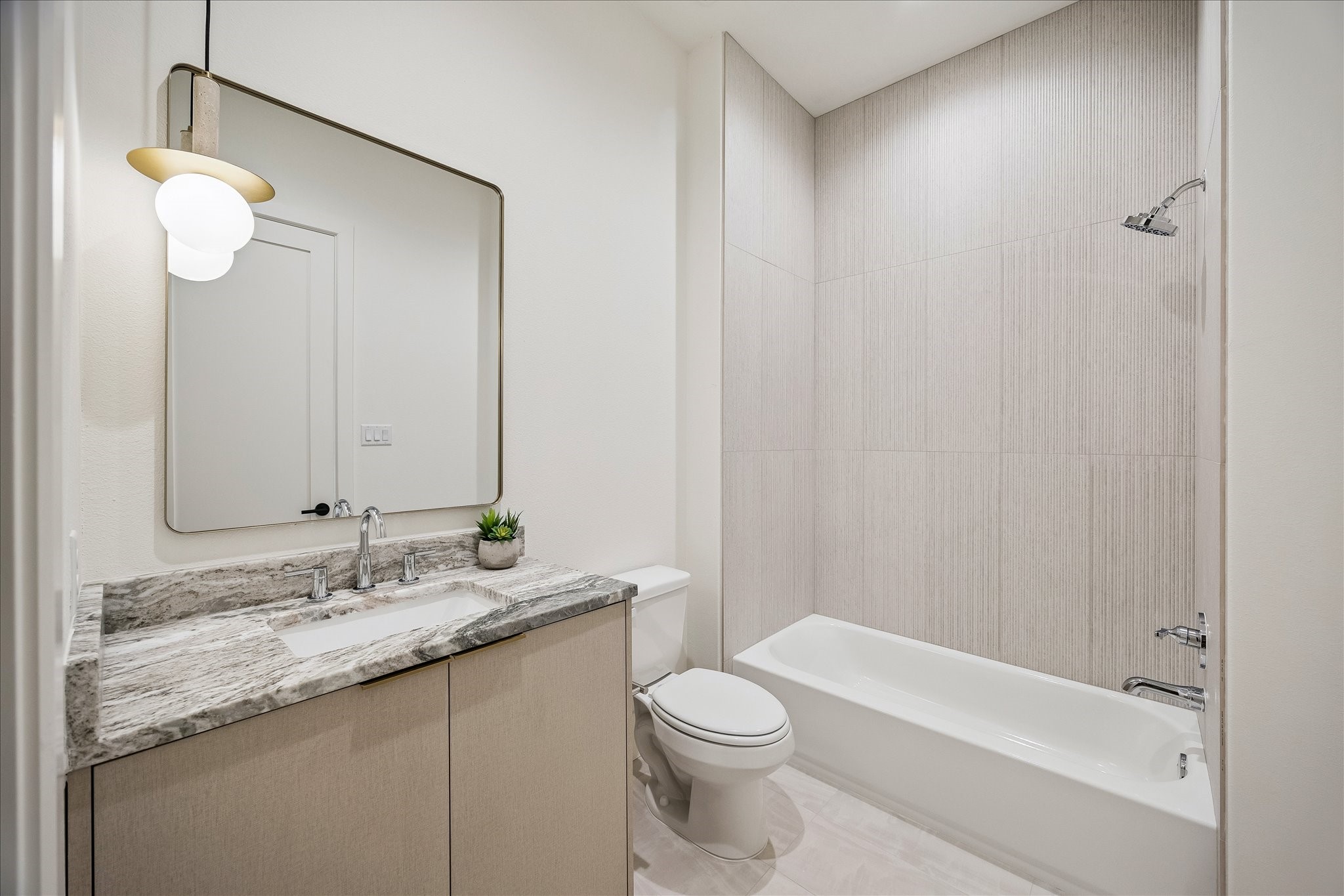 335 Harvard Street Houston, TX 77007 - Photo 25 of 35 En-suite bath #4 - features a shower/tub combo, designer lighting fixture, and dual access from the bedroom and hallway.