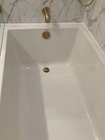 a view of a room with a bed and wooden floor