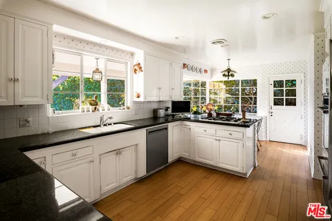 a dining room with wooden floor a chandelier a wooden table and chairs