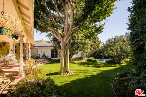 a front view of a house with garden and sitting area