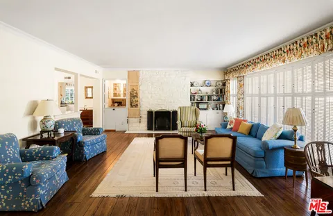 a living room with fireplace furniture and a wooden floor