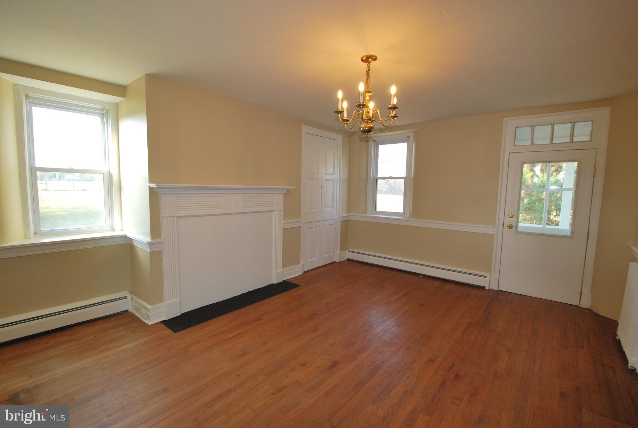 592 Blake Road Elkton, MD 21921 - Photo 7 of 18 an empty room with wooden floor chandelier and windows