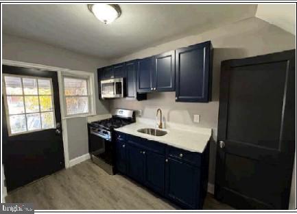 133 Riverthorn Road Middle River, MD 21220 - Photo 3 of 5 a kitchen with a sink a refrigerator and wooden cabinets
