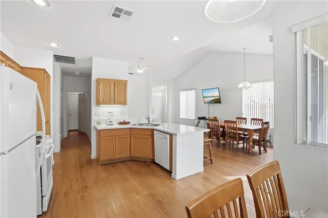 a kitchen with sink refrigerator dining table and chairs