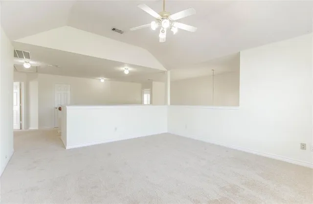 an empty room with a ceiling fan and a window