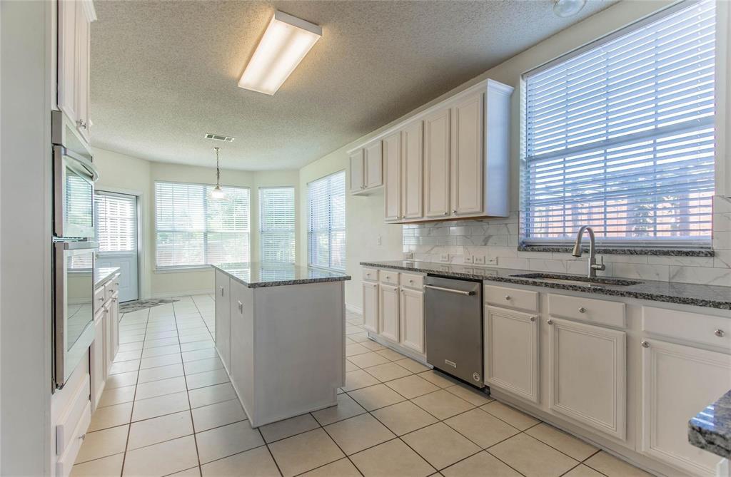 4136 Los Altos Drive Plano, TX 75024 - Photo 22 of 31 a kitchen with granite countertop a sink a counter top space and cabinets