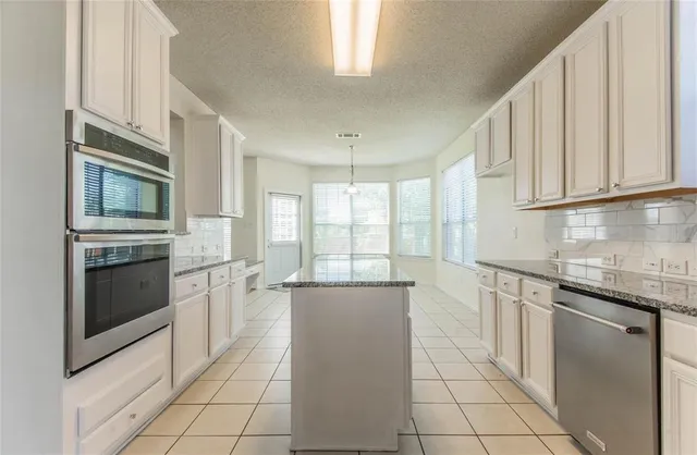 a kitchen with a stove a sink and a microwave