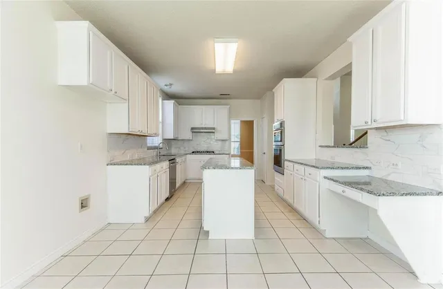 a kitchen with a sink a counter top space and cabinets