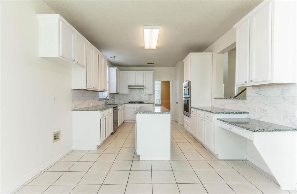 4136 Los Altos Drive Plano, TX 75024 - Photo 4 of 31 a kitchen with a sink a counter top space and cabinets